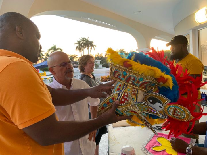 Bahamian_Junkanooer_sharing_on_the_craftsmanship_of_the_Junkanoo_costume_to_a_guest_at_Bahamas_Haus.jpg